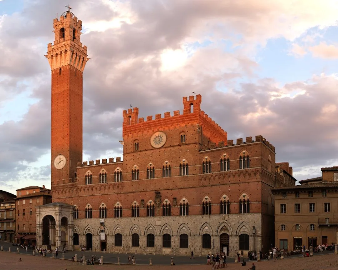 The shell-shaped Piazza del Campo in Siena at dusk with the Torre del Mangia above it