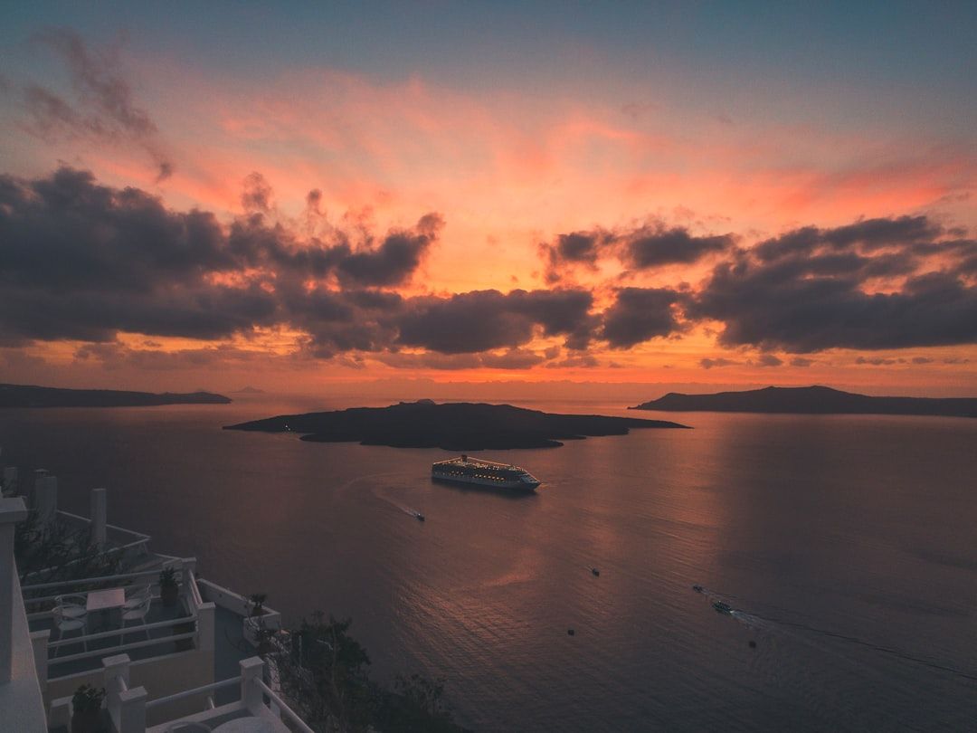 The sun setting over the Santorini caldera seen from a boat on the water